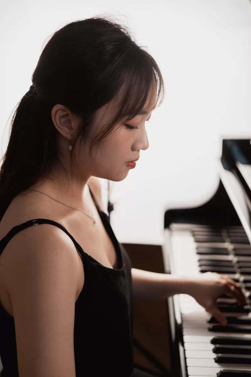 Pianist playing a piano with a bright white background