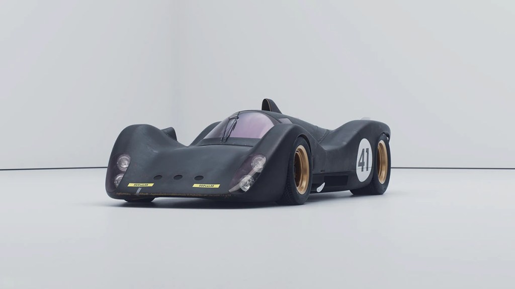 Render hiperrealista de un coche de carrera negro con detalles en dorado y el número 41, sobre un fondo blanco, evocando un prototipo de automóvil olvidado.