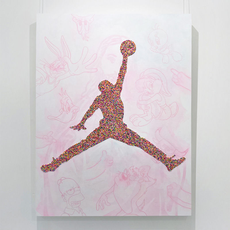Arte que representa la figura icónica de un jugador de baloncesto, formada por sprinkles de colores brillantes, sobre un fondo con dibujos de personajes animados clásicos.