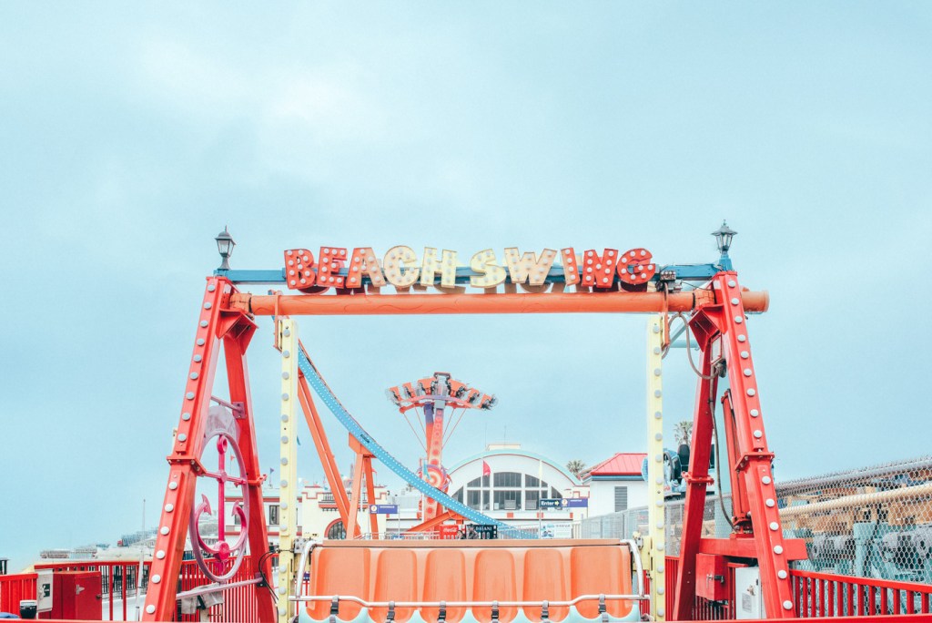 Puente de atracción 'Beach Swing' en un parque de diversiones, con fondo de cielo nublado.