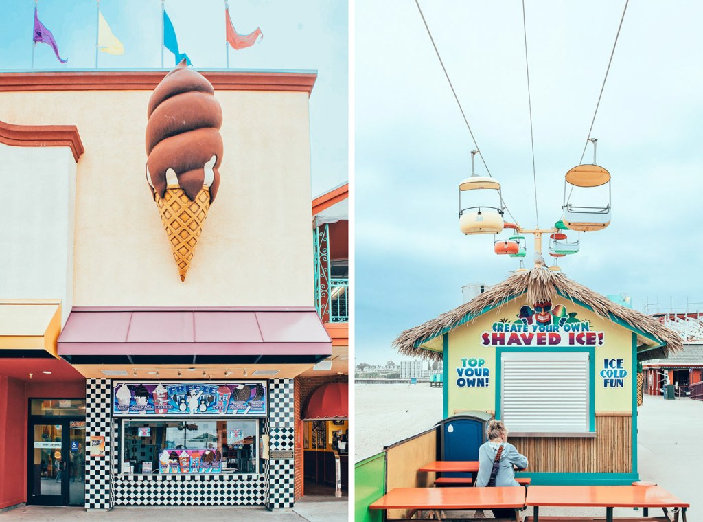 Un gran helado de chocolate en la fachada de una tienda, con banderas de colores al fondo; a la derecha, un puesto de hielo raspado con decoración de palma y una plataforma de telesillas encima.
