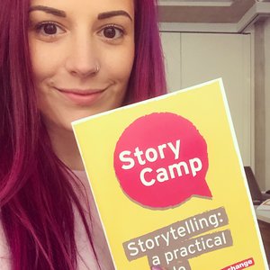 Cara Lisette holding a Story Camp leaflet