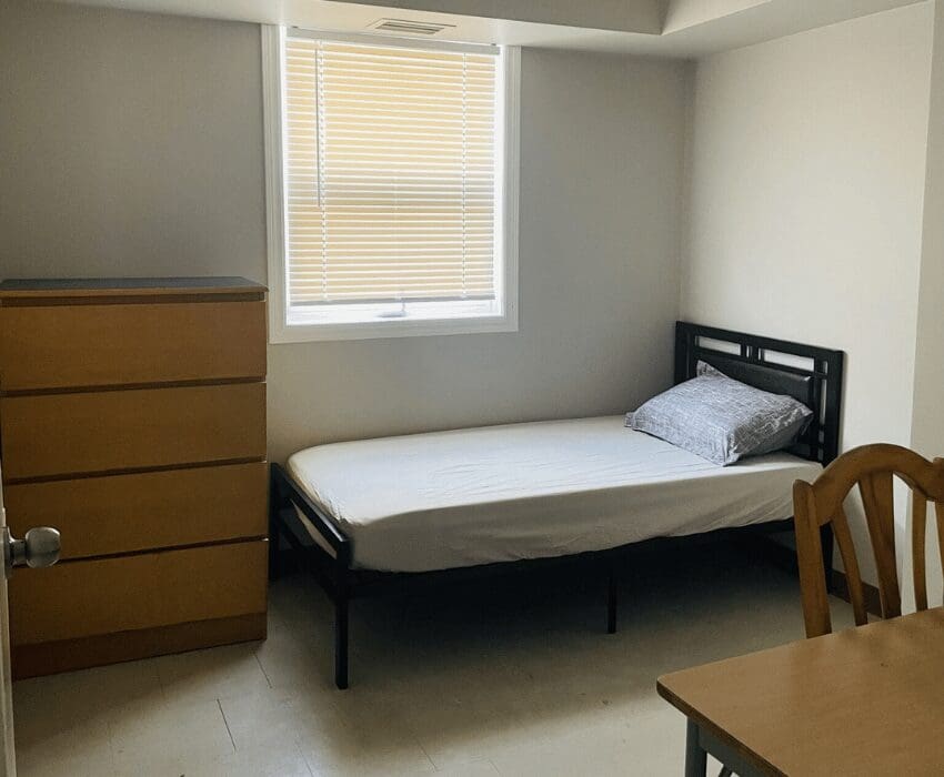 shelter bed in a room with a dresser and night stand