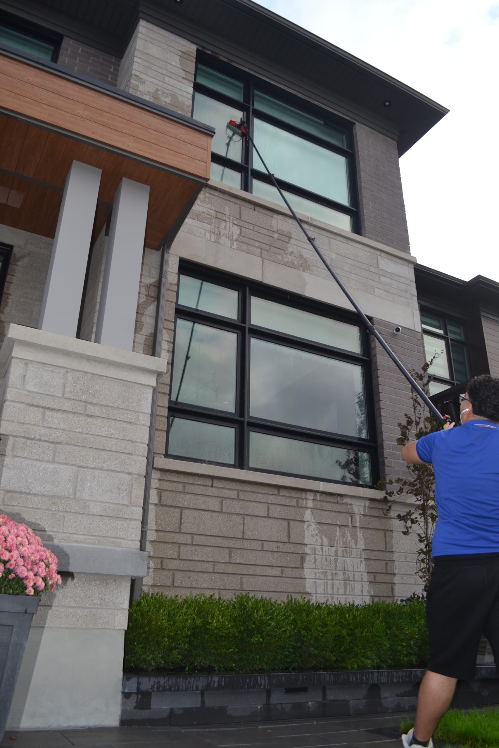Pine Cleaners technician cleaning second-story window using water-fed pole in Vaughan