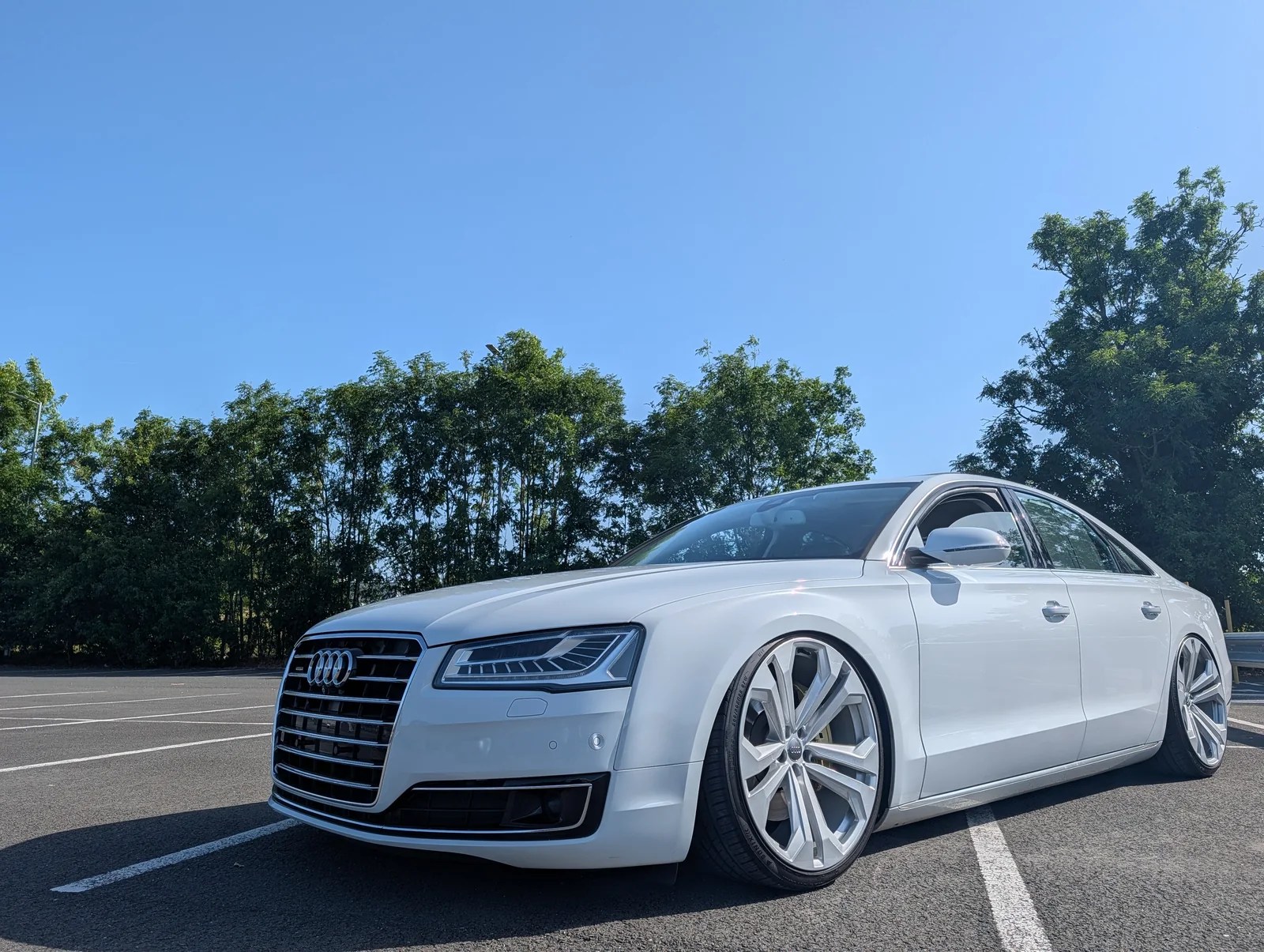 White Audi A8 with a lowered stance, photographed from the front three-quarter angle.