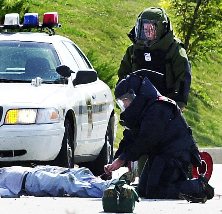 The Erie police’s bomb squad examines the dead body of Brian Wells after a collar bomb locked to his neck exploded. JANET B. KUMMERER/ERIE TIMES-NEWS