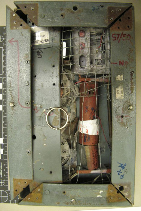 The FBI lab in Quantico, Va., used evidence collected from the scene of the bomb blast to reconstruct the bomb mechanism that hung from the neck of Brian Wells. Only one of the pipe bombs exploded. A metal plate covers the kitchen timers that were so crucial to the bomb’s design; the metal mesh was a booby trap designed to detonate the bomb if the mesh touched the metal of the frame. The entire contraption weighed 10 to 15 pounds. FBI photo, used as evidence at trial