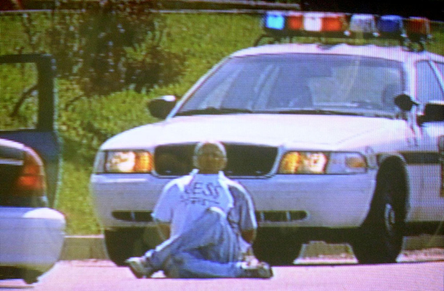 Pizza deliveryman Brian Wells moments before the collar bomb locked to his neck exploded, killing him instantly. He had just robbed a bank in Summit Township, outside Erie, Pennsylvania, on August 28, 2003. The bomb is underneath his white T-shirt, which is a knockoff for Guess jeans. Wells’ hands are cuffed behind his back. "I don’t have a lot of time," Wells told the Pennsylvania State Police. WJET-TV, the ABC affiliate in Erie, filmed the entire episode. ERIE TIMES-NEWS, COURTESY OF WJET-TV