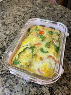 Egg protein bowl with chopped sausage, ham, red onion, bell pepper, spinach, and melted muenster cheese.
