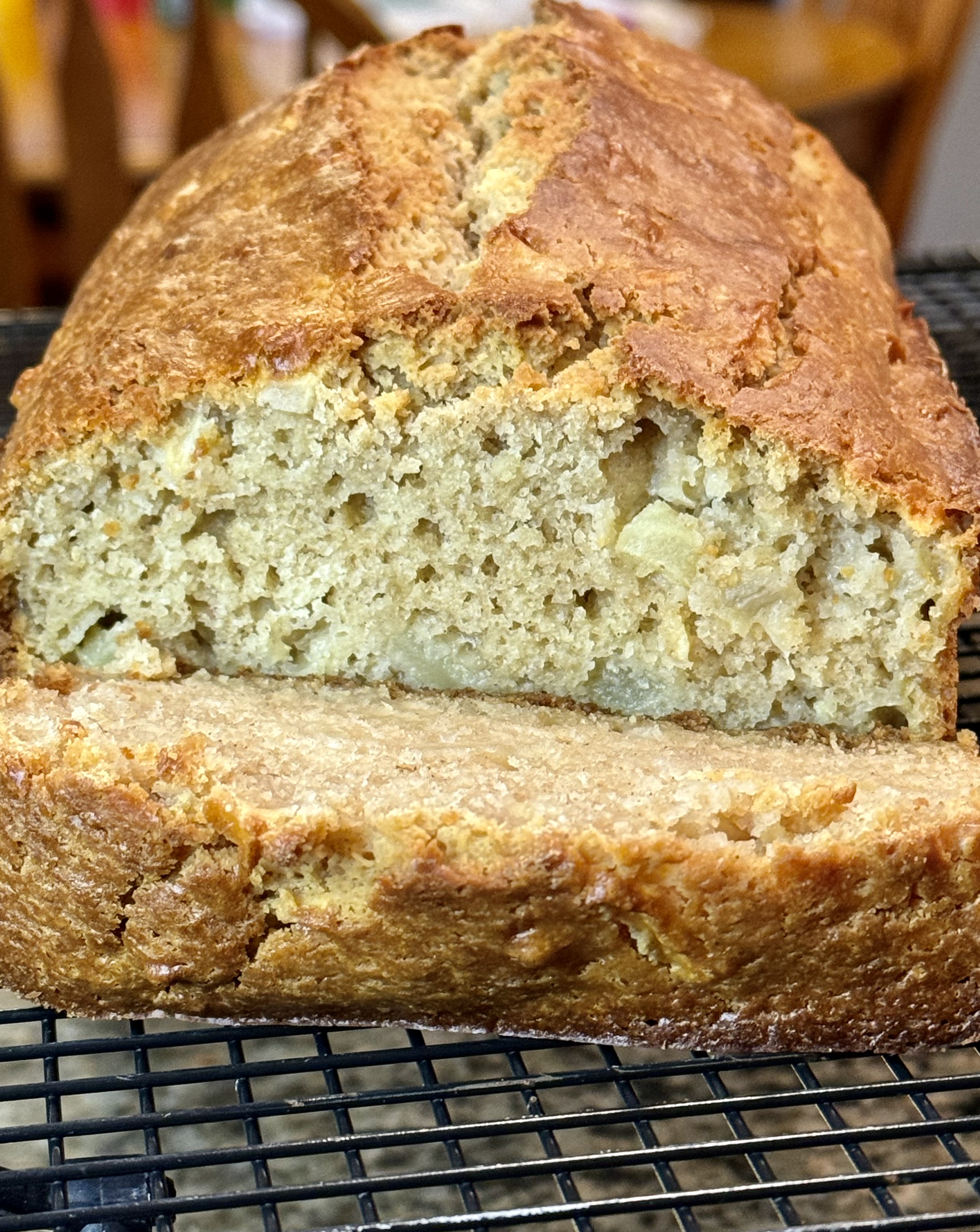 Apple cinnamon bread on a black cooling rack.