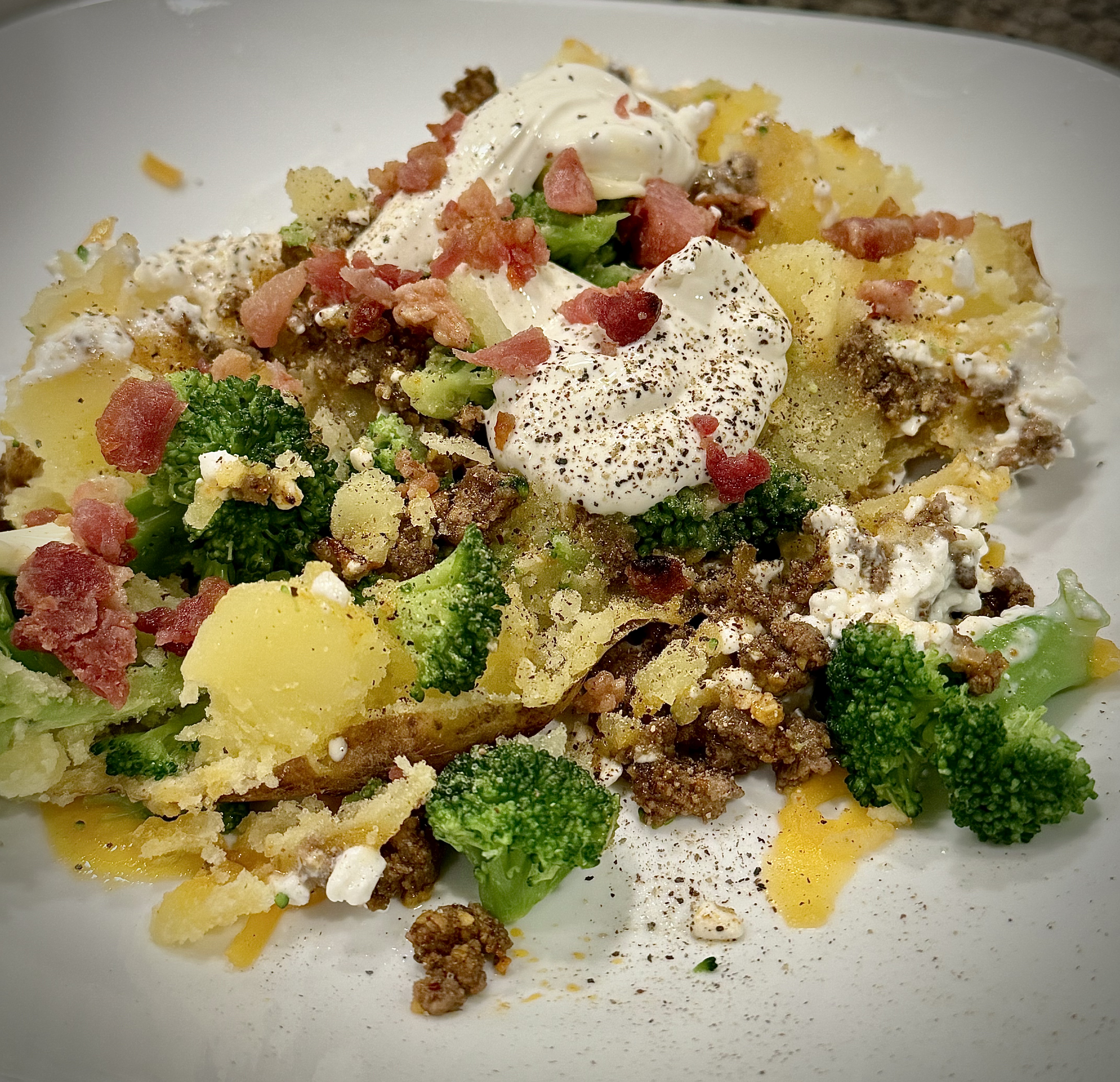 Baked potatoes on a plate with a variety of toppings.
