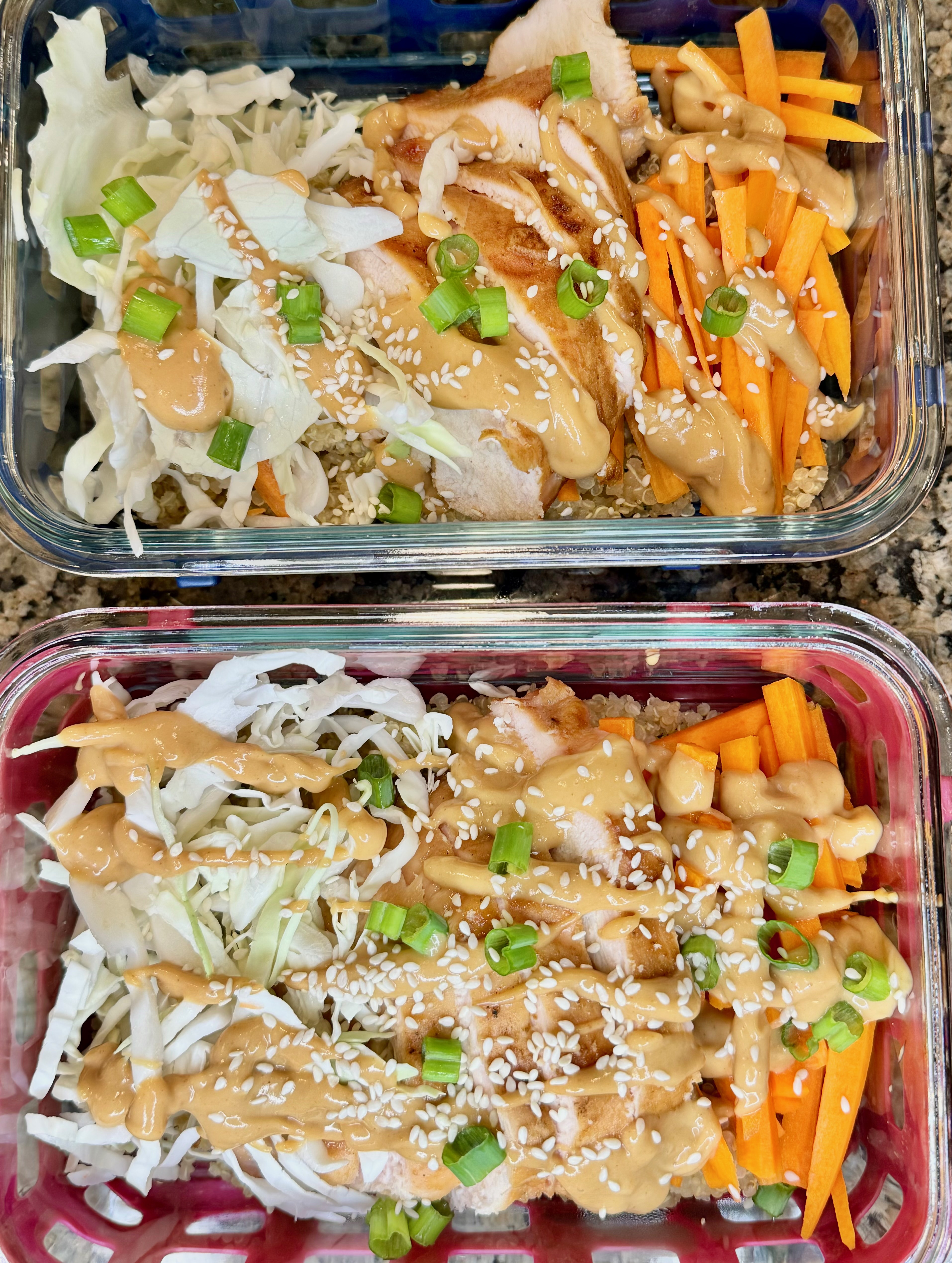 Colorful Thai peanut chicken bowls with quinoa, cabbage, carrots, and green onion topped with creamy peanut sauce
