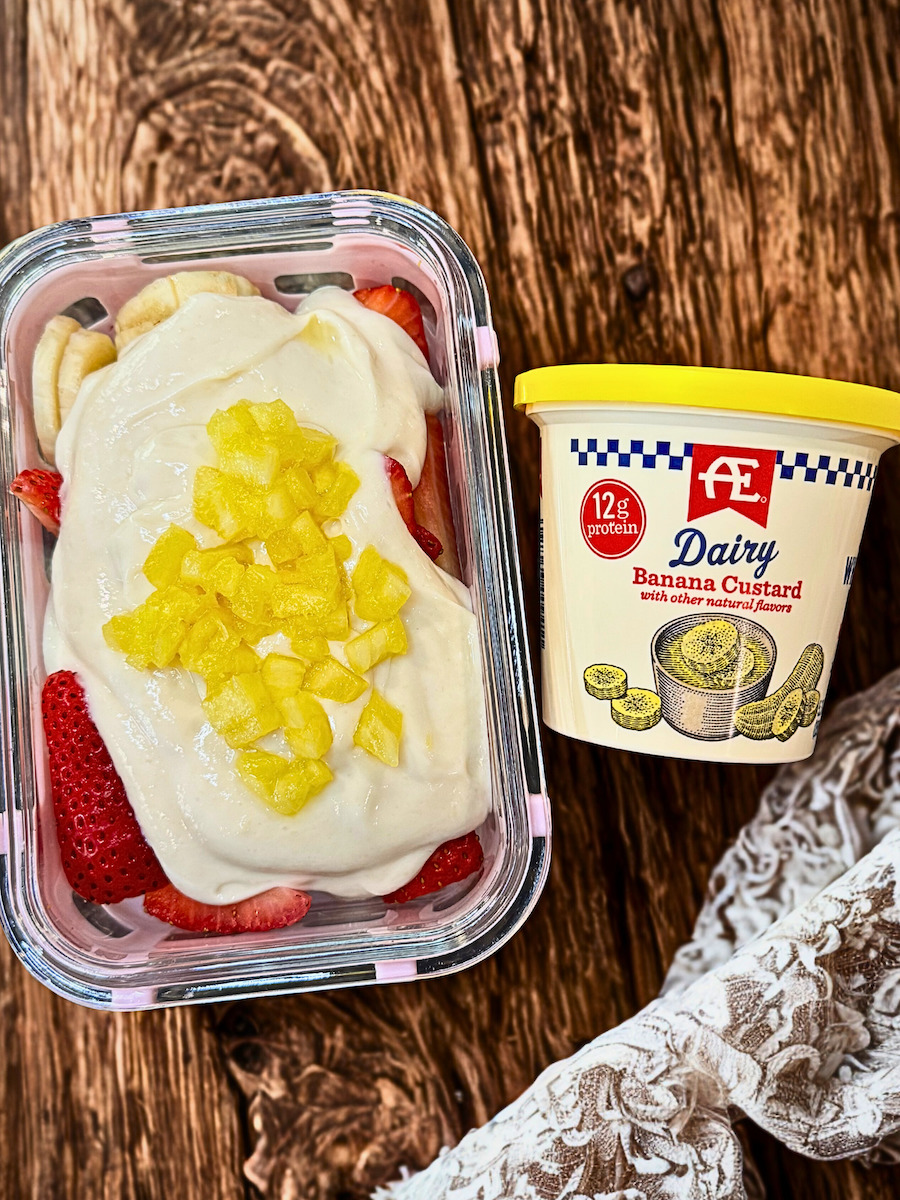 High-protein banana split yogurt bowl with strawberries, banana, pineapple, and creamy banana custard yogurt and protein mix.