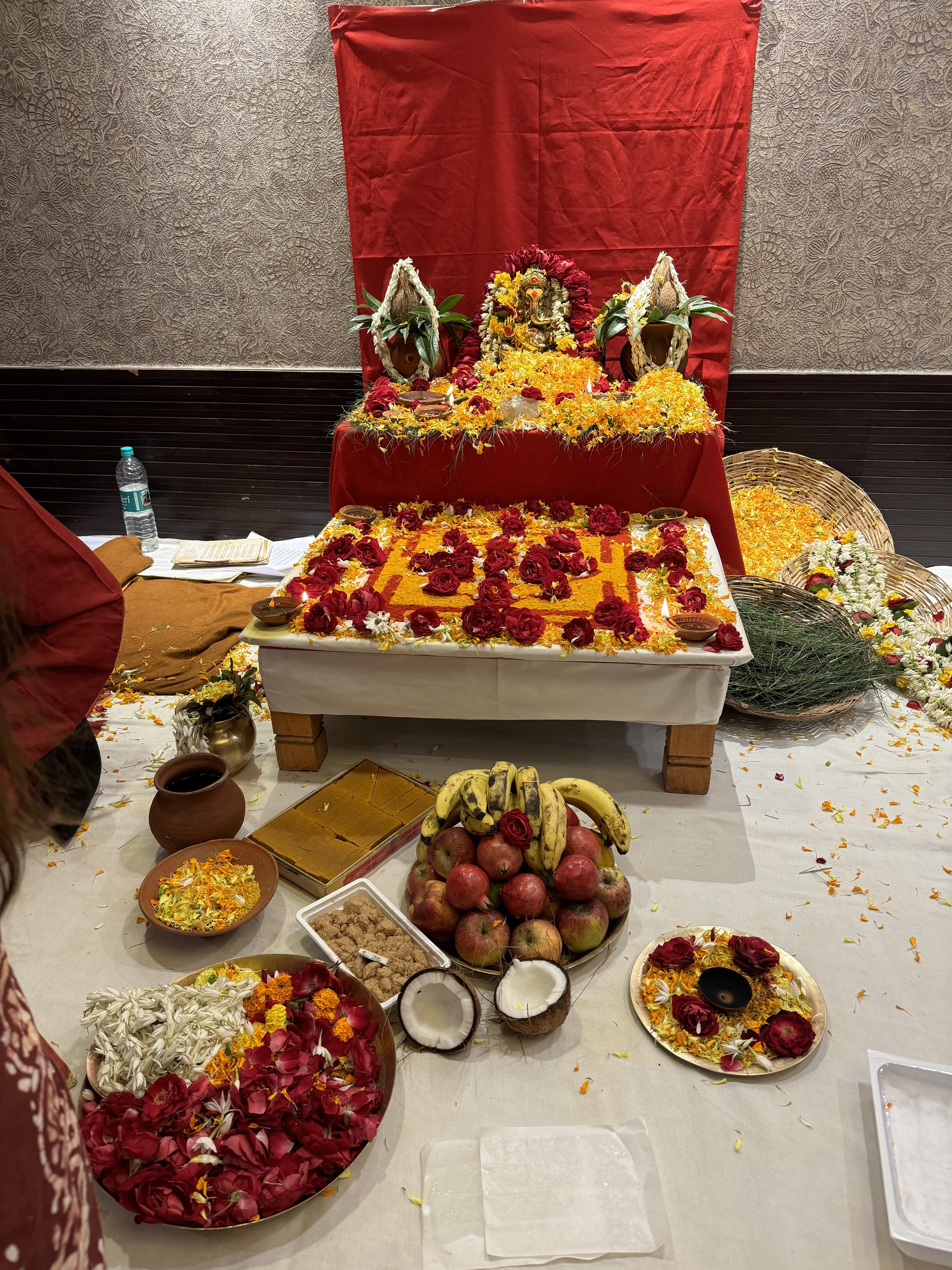 Flowers, fruit, coconuts, and offerings arranged for a ceremony in India