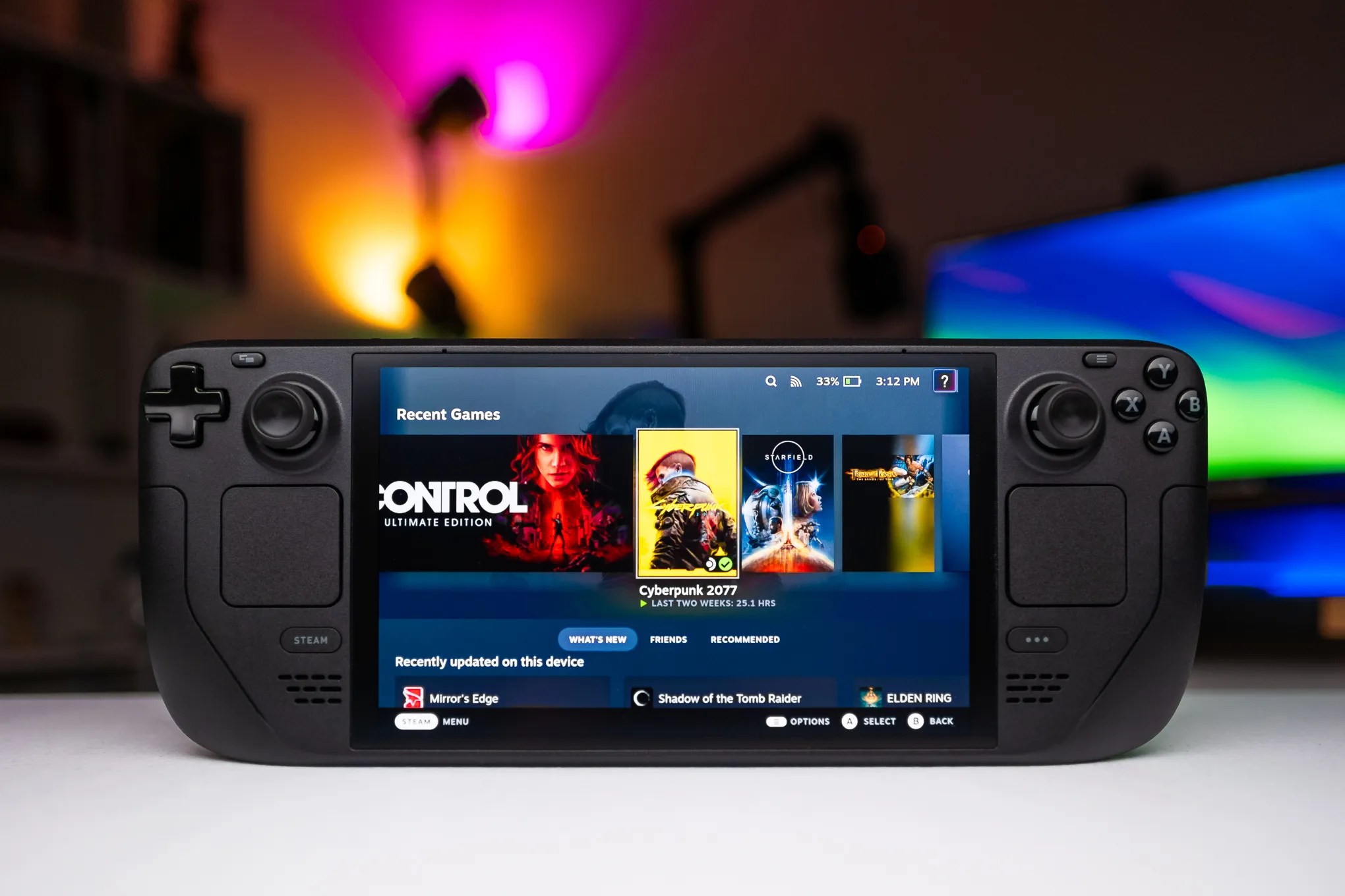 An OLED Steam Deck showing the Steam interface with games including Control