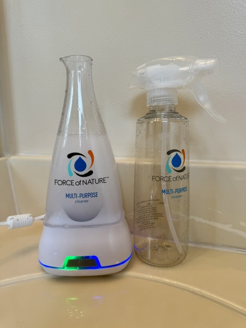 Force of Nature cleaning solution and spray bottle sitting on bathroom counter. 