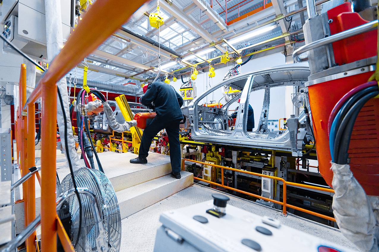 Engineer assemble the car on the production line. Car manufacturing plant