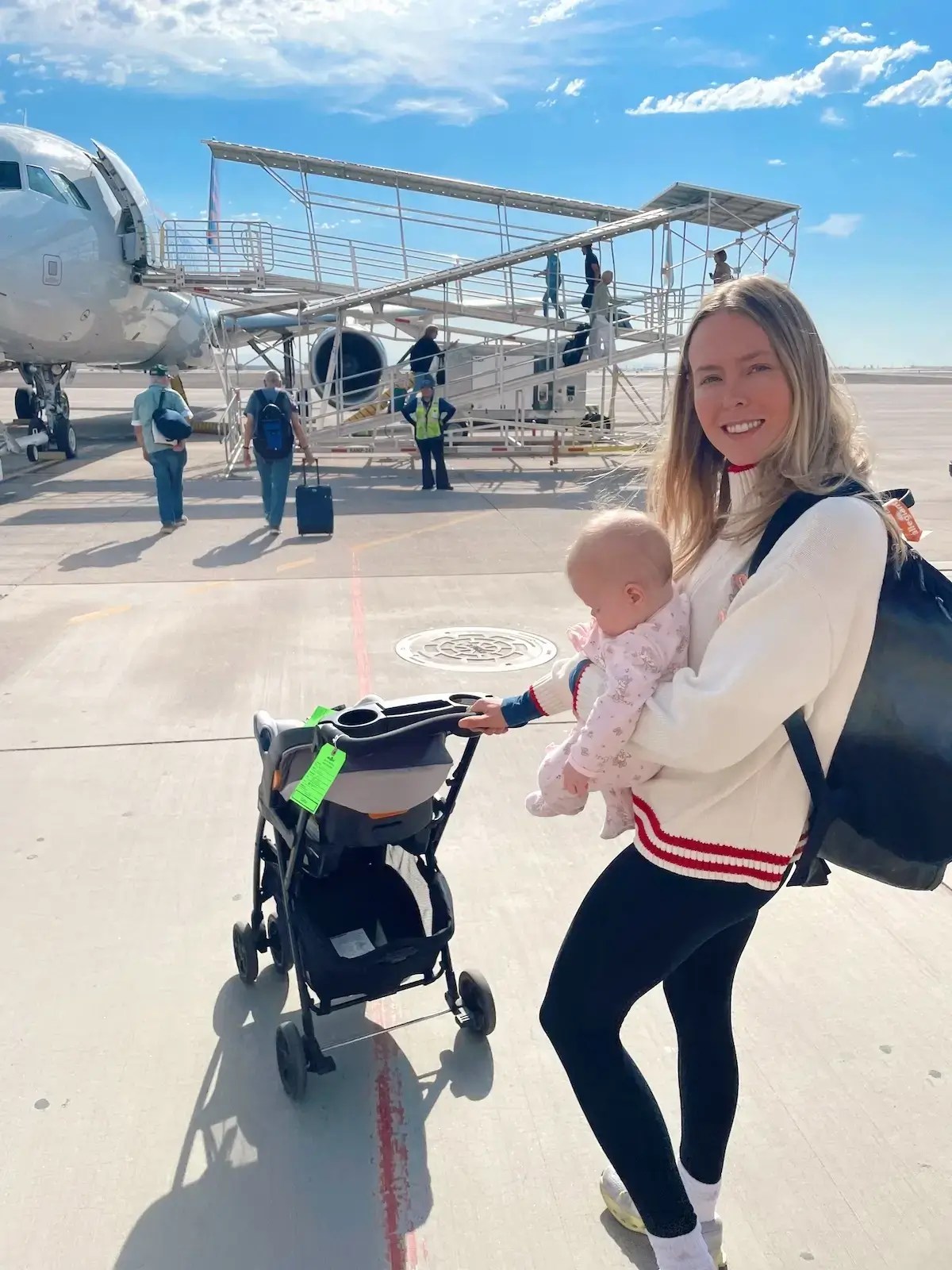 Mom and baby walking up to the plane to go on baby's first flight.