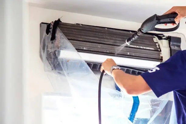 Experienced HVAC technician testing airflow and electrical components during detailed AC maintenance, HVAC technician inspecting electrical connections and airflow during advanced AC system service