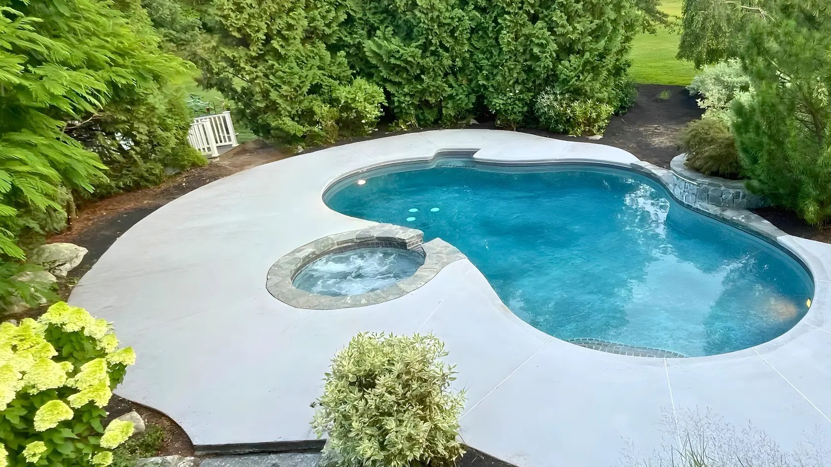 Gunite pool and spa renovation in Connecticut with updated coping, resurfaced interior, and clean concrete deck