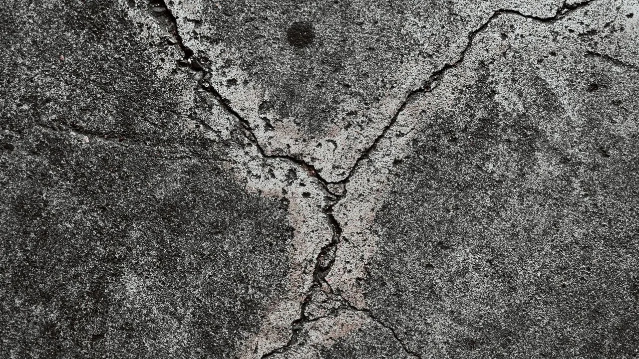 Cracked concrete pavement showing settlement damage