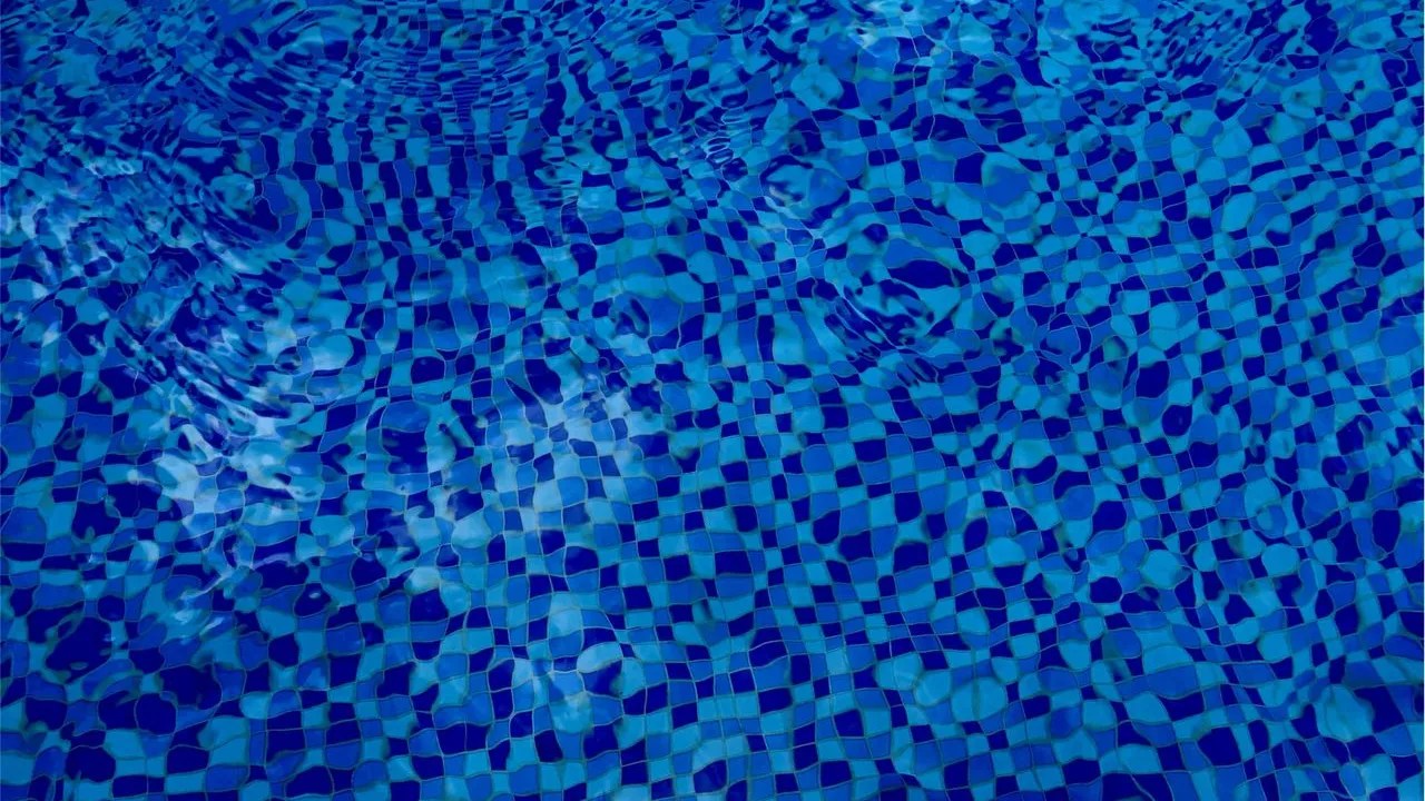 Blue and white waterline tiles with clear pool water
