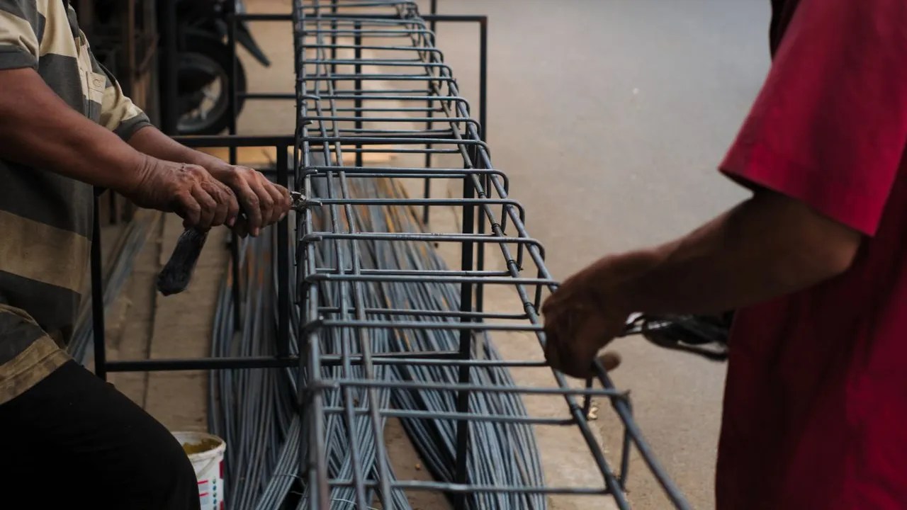 Workers tying steel rebar for new concrete construction