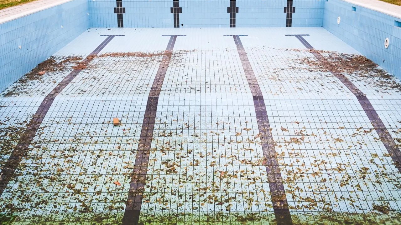 Drained concrete pool showing worn interior awaiting remodeling