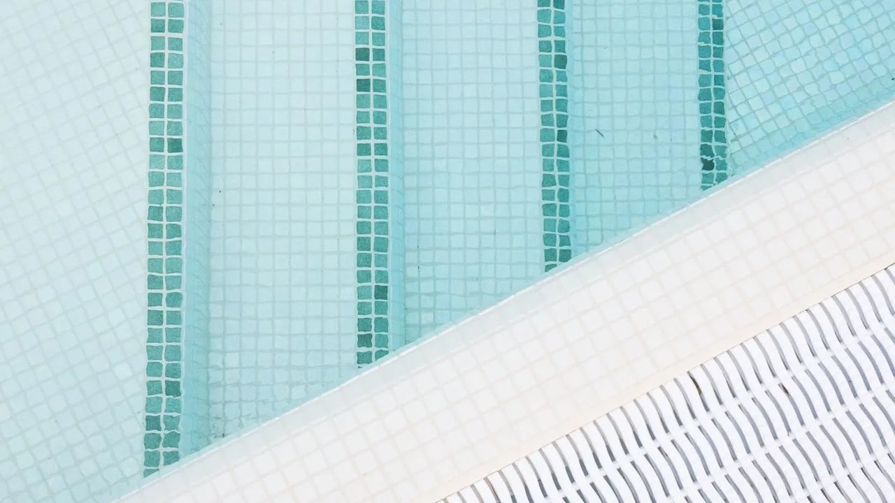 Aqua waterline tile band on a swimming pool wall