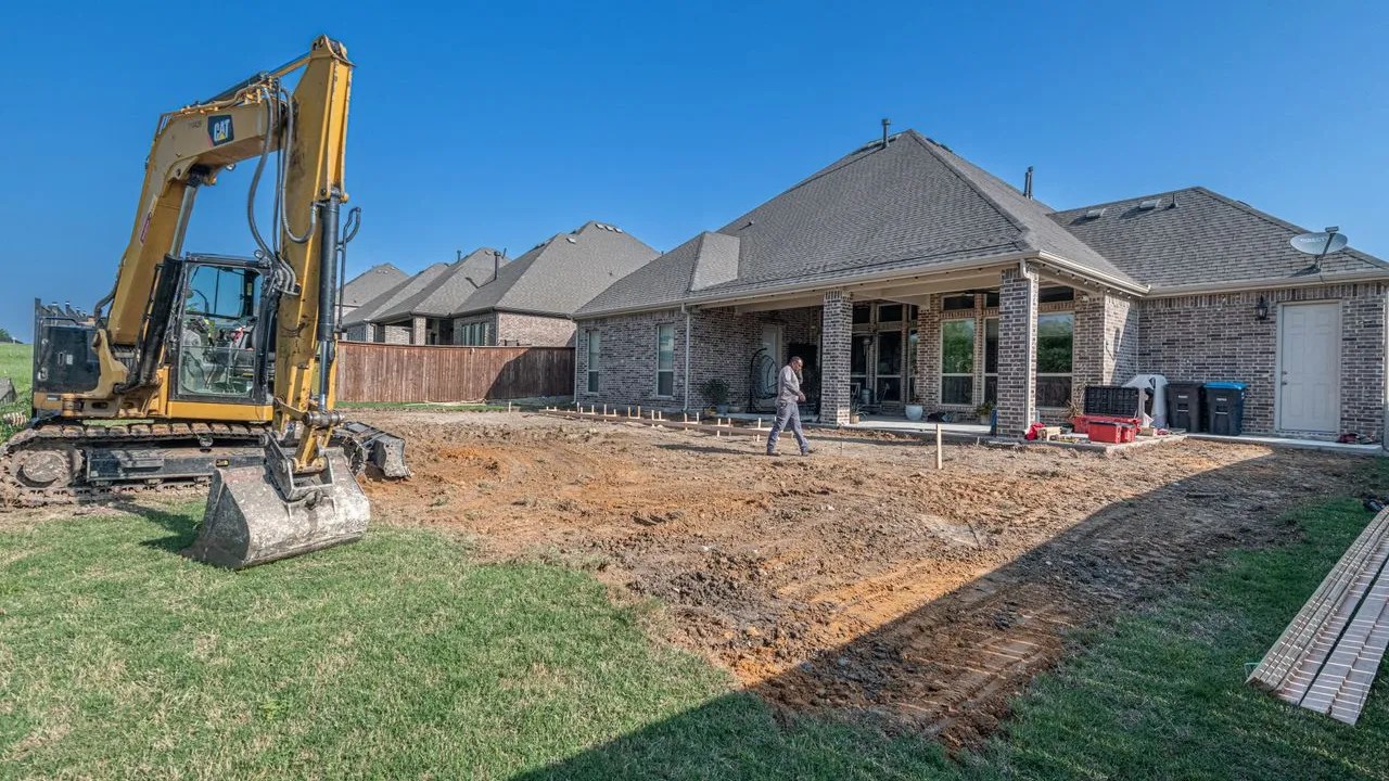 Excavator working on a backyard construction site