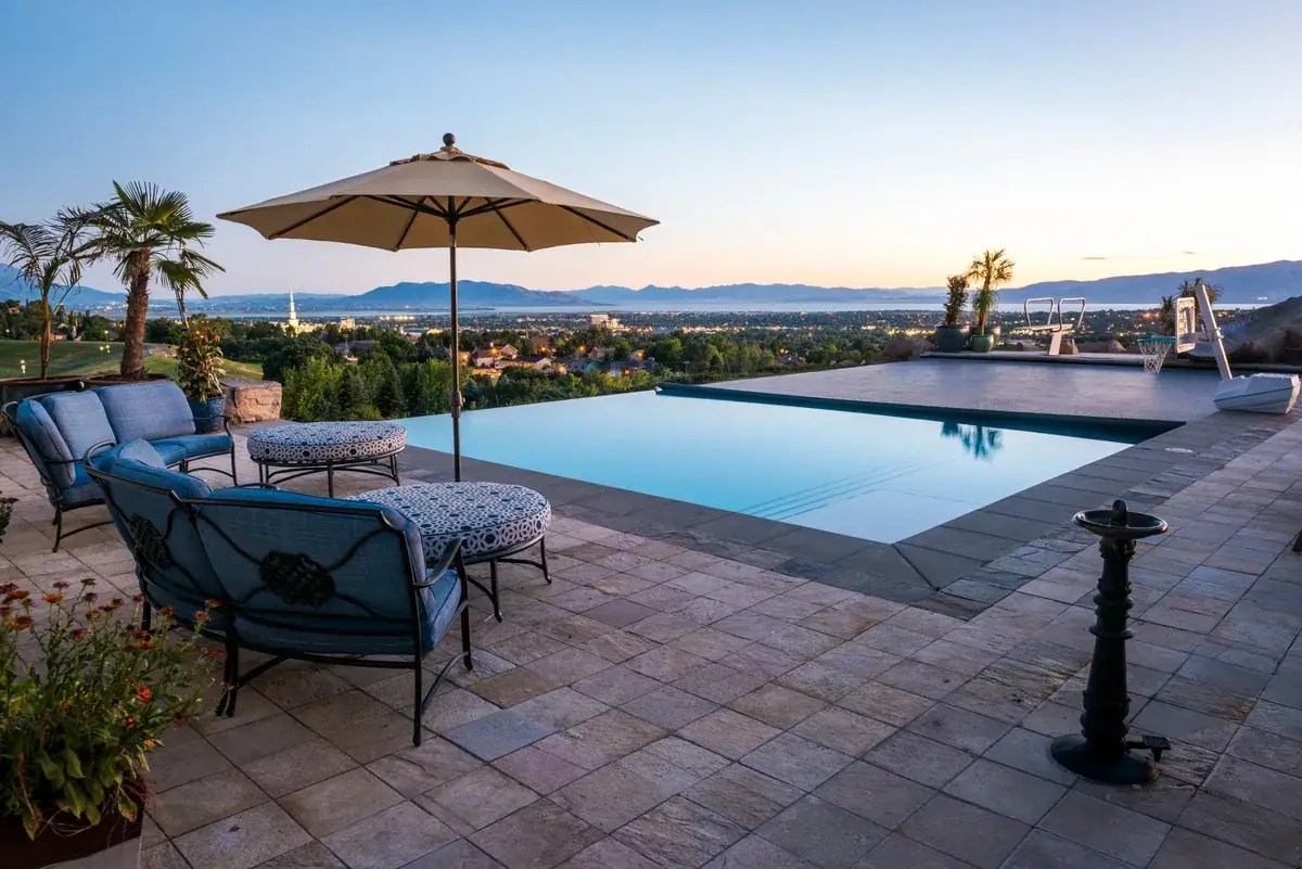 Automatic pool cover for infinity pools: vanishing edge pool at dusk with the cover partly closed