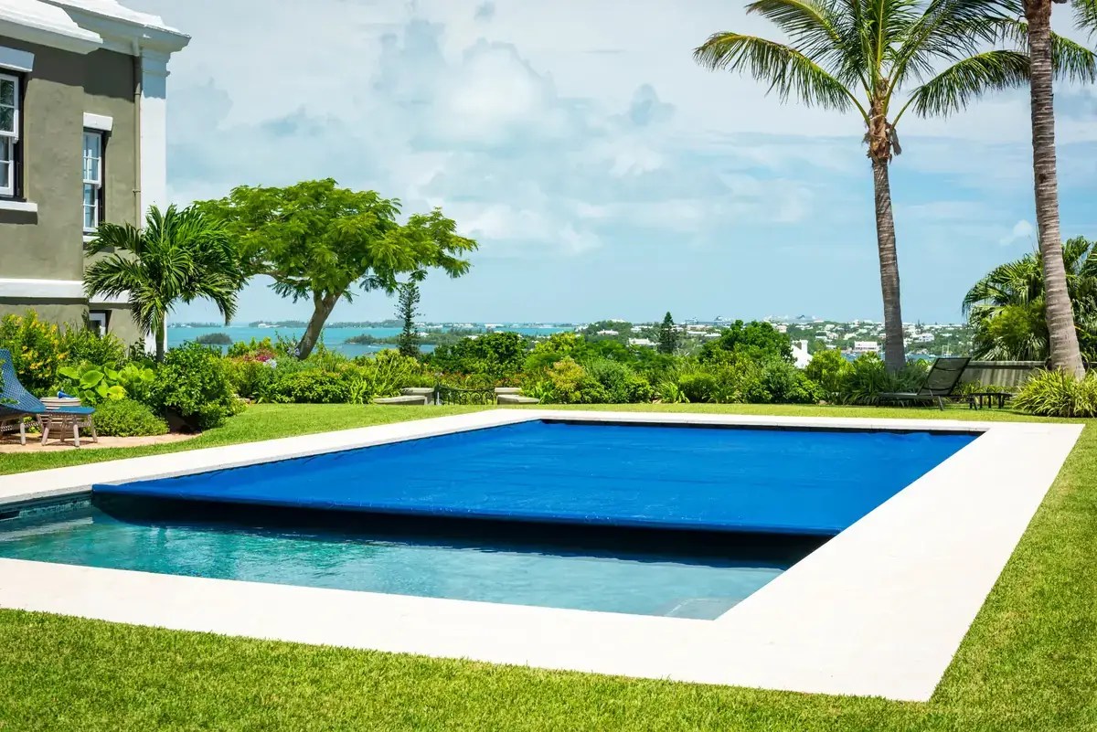 Blue automatic pool cover partly open on a rectangular pool
