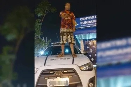 Em afronta, jovens sobem em carro da PM e fazem sinal de arma