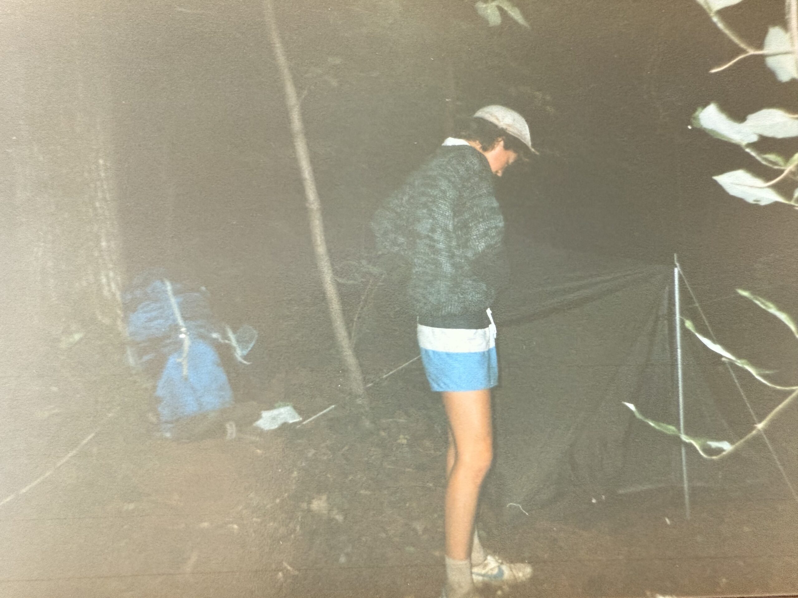 Young man erects a tent in the dark on the Appalachian trail.