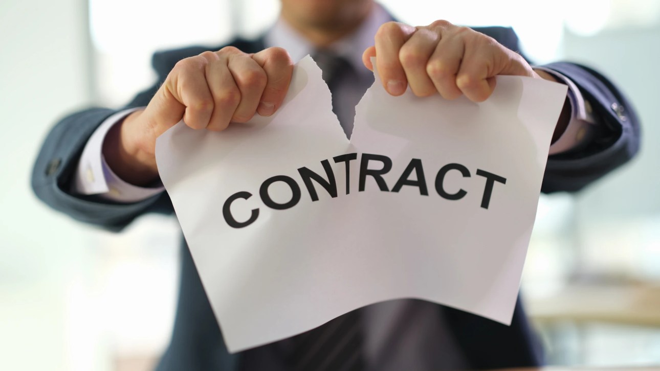 voidable contract- A man tearing a paper sheet with the word contract