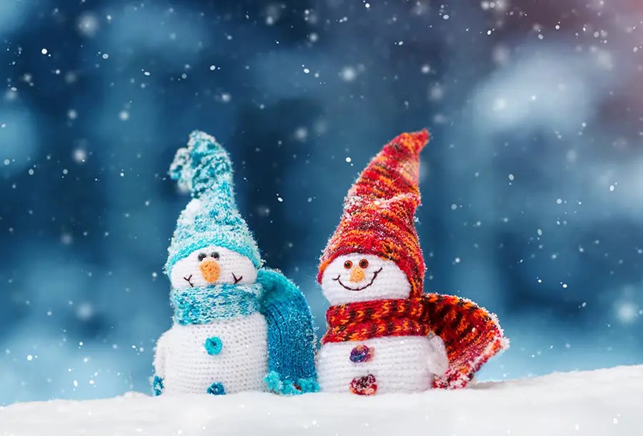 Two cheerful snowmen in colorful hats and scarves, symbolizing lawyers and mediators keeping things cool in negotiations.