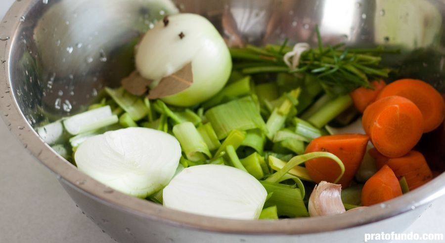 Mix de vegetais cortados dentro de uma tigela de metal para fazer caldo de legumes visto de lado