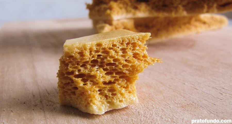 Peda&ccedil;o de Honeycomb Candy em detalhe sobre t&aacute;bua de madeira