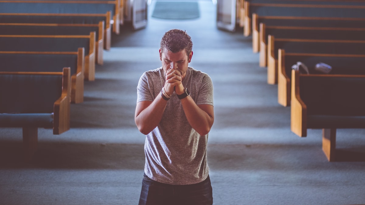 A man standing alone in prayer, asking God for strength against temptation