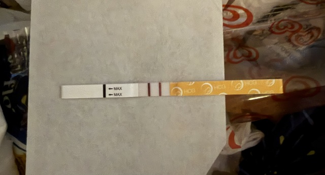 A positive Premom HCG pregnancy test strip.  