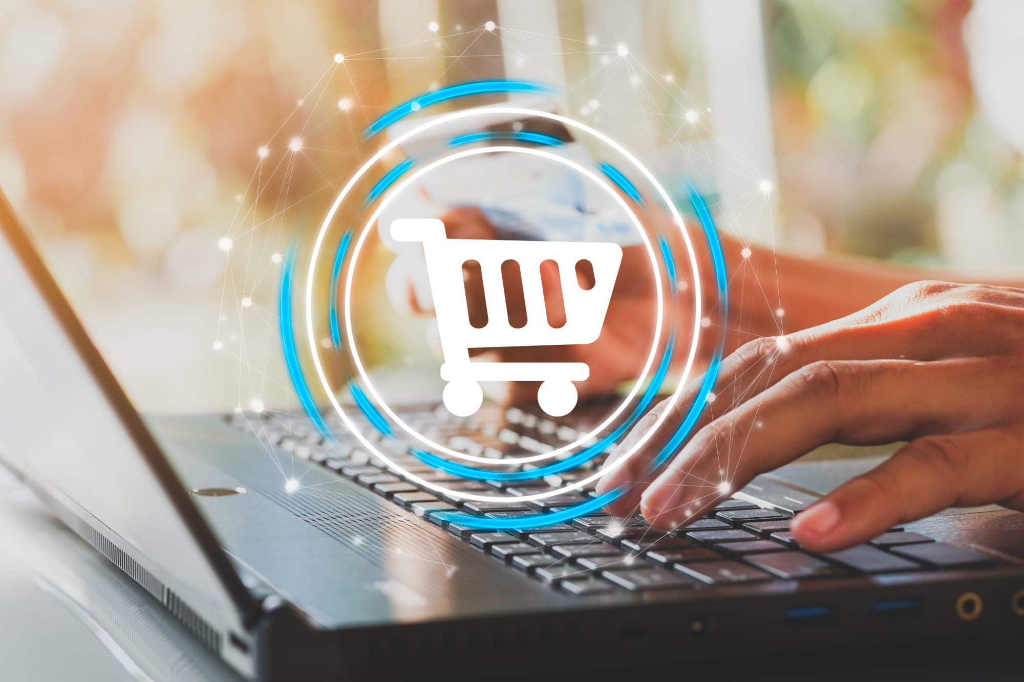 Hands typing on a laptop keyboard with a digital shopping cart icon overlay.