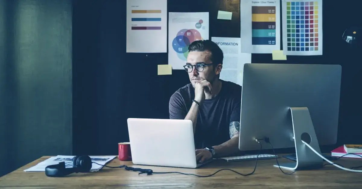 Employee thinking at desk with computer