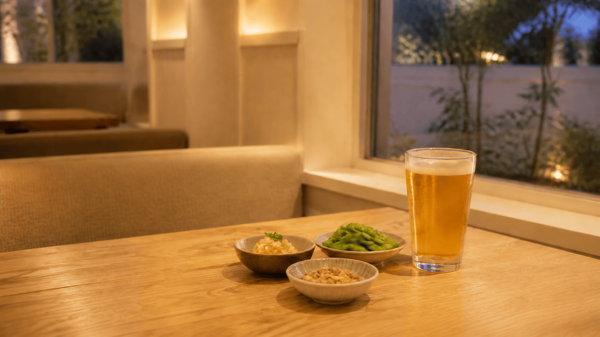 夕方のレストランのテーブルに並ぶビールのグラスとおつまみの皿