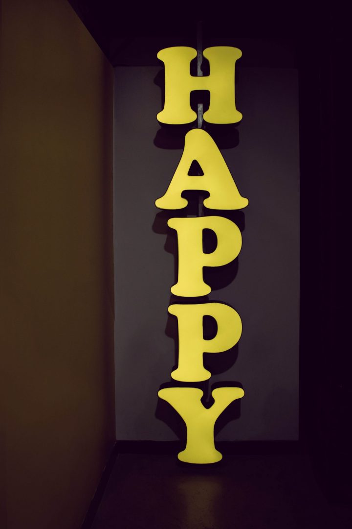 Yellow lettered sign reading "Happy" going down the wall