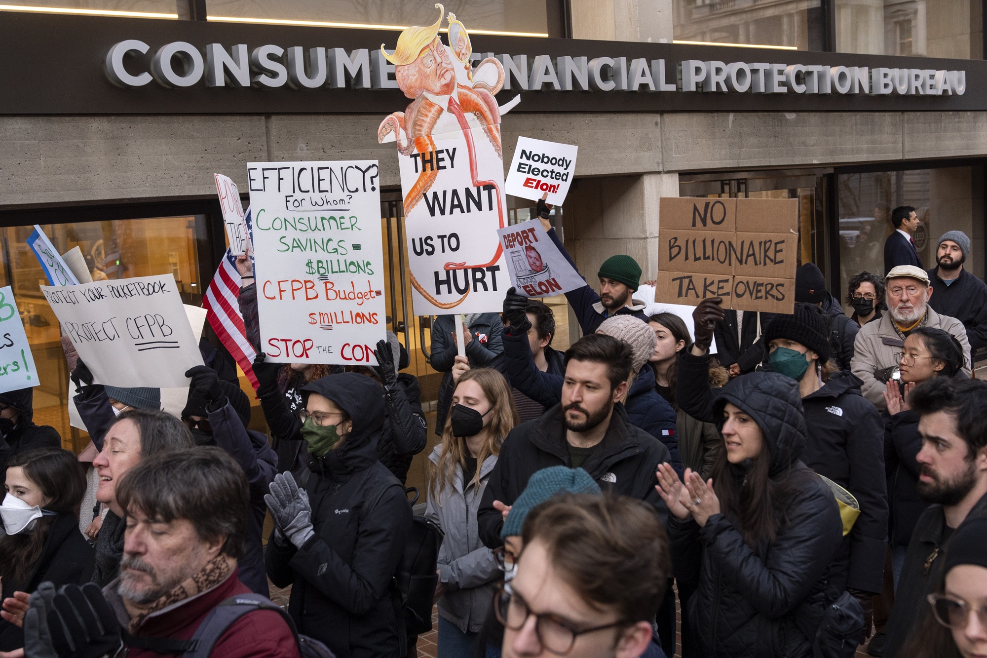 People attend a protest in support of the Consumer Financial Protection Bureau