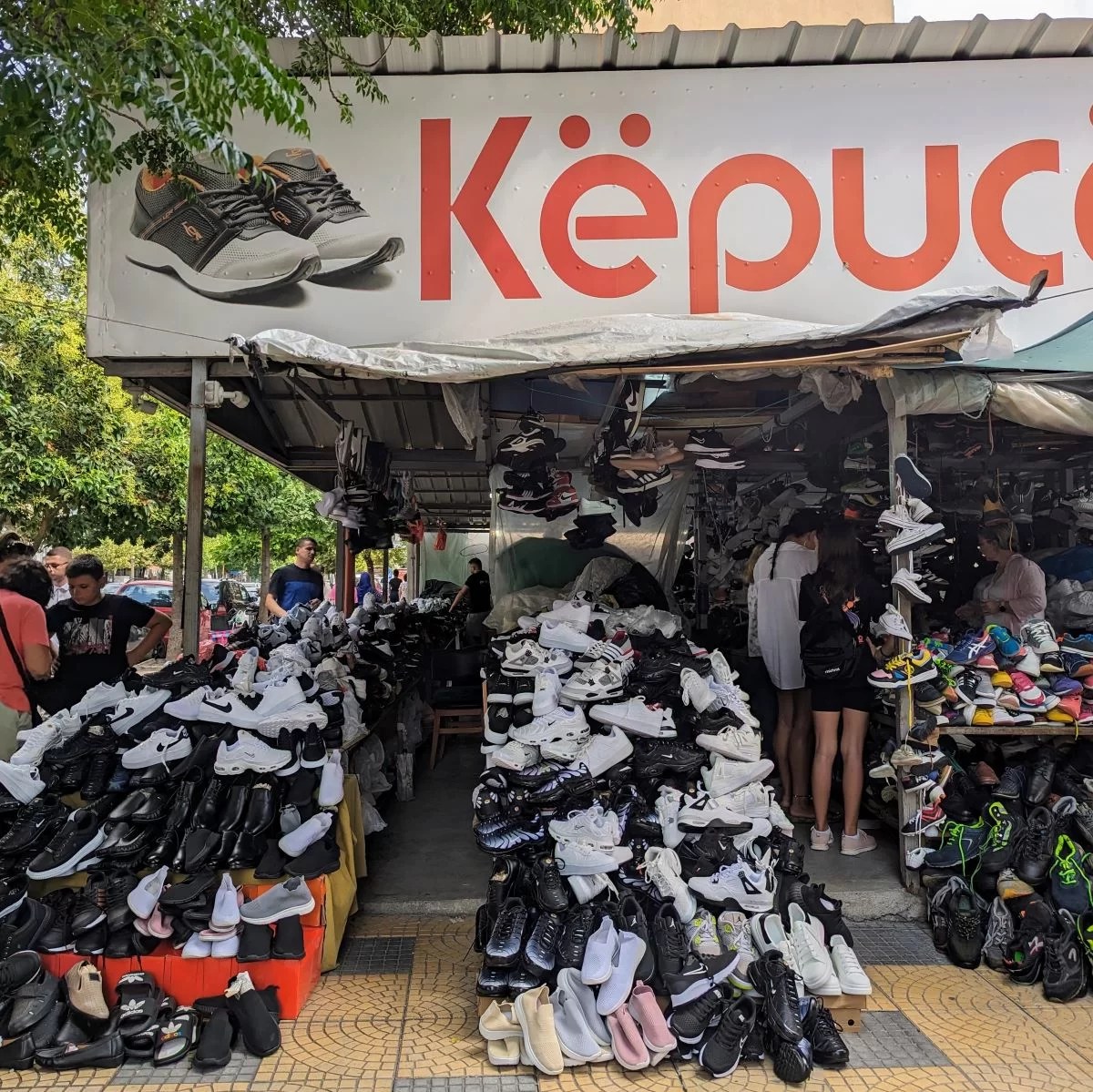 piles of shoes being sold at outdoor market in Shkoder Albania