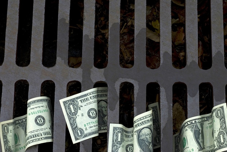 US Dollar bills down the drain