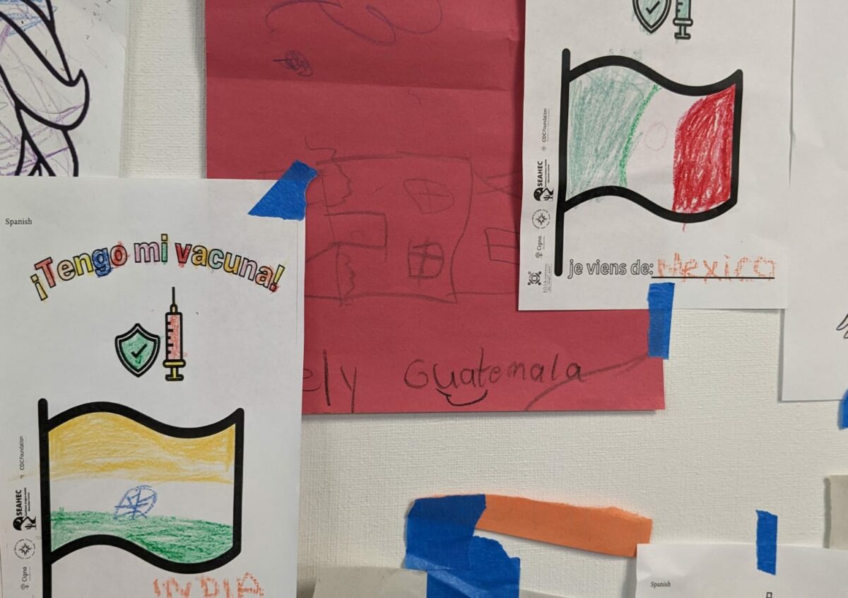 Images of colored flags with COVID-19 vaccination messaging at a community health center.