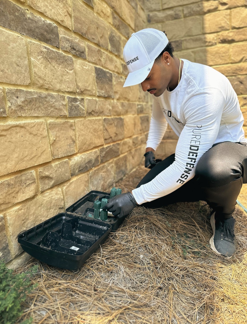 pure defense pest control team placing a rodent bait box as a a part of their rodent control system