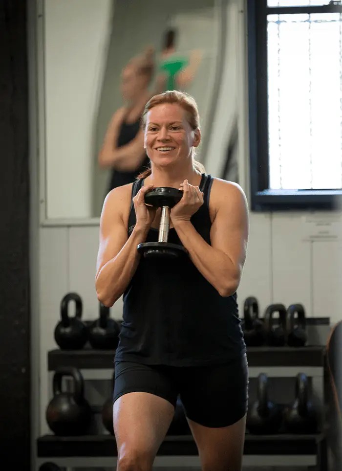 A QSMC client during an Exercise Physiology appointment performing lunges with a dumbbell weight